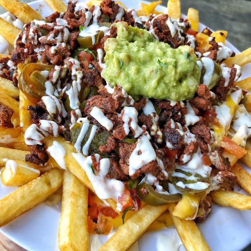 Teresa's Mexican Grill's carne asada fries, topped with guacamole, jalapeños, and white sauce.